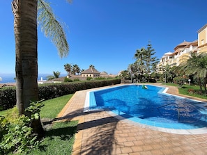 A swimming pool with a clear view of the ocean and a residential area with houses. - Holiday Home in Nerja With Sea Views (Nerja)
