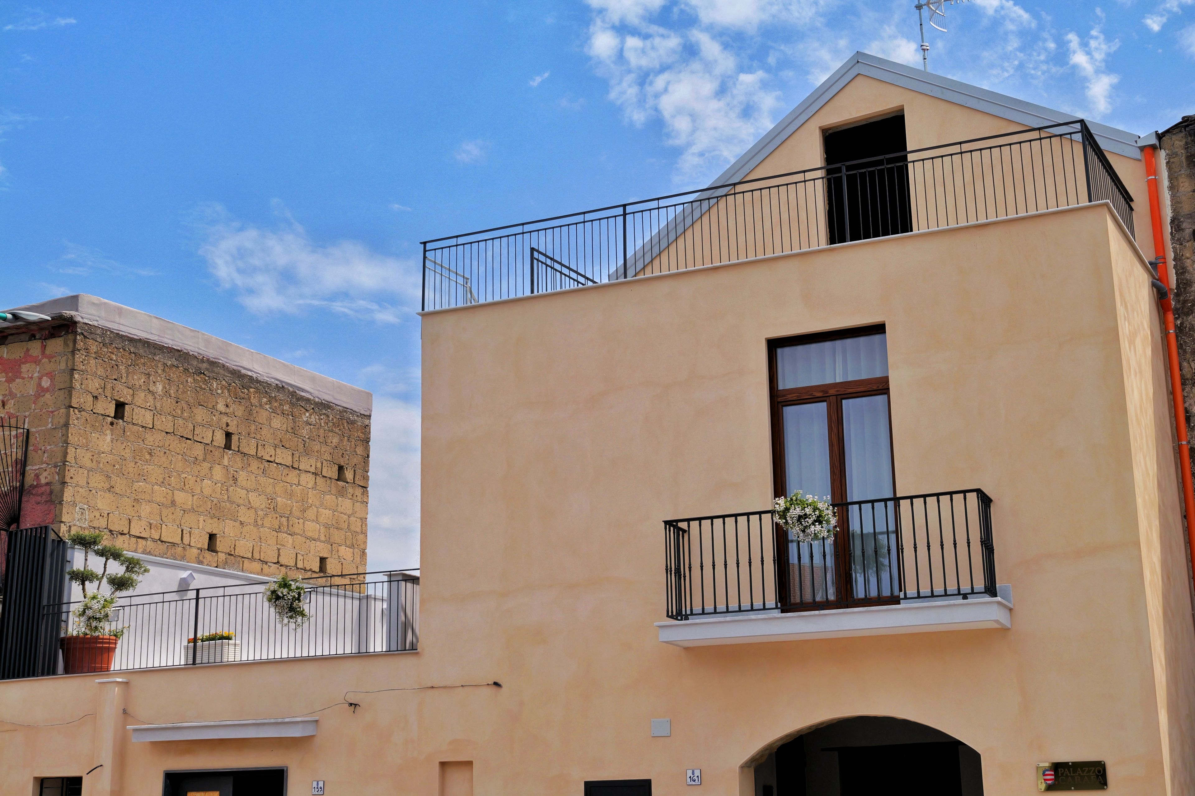 A building with a balcony, a window, and a door.