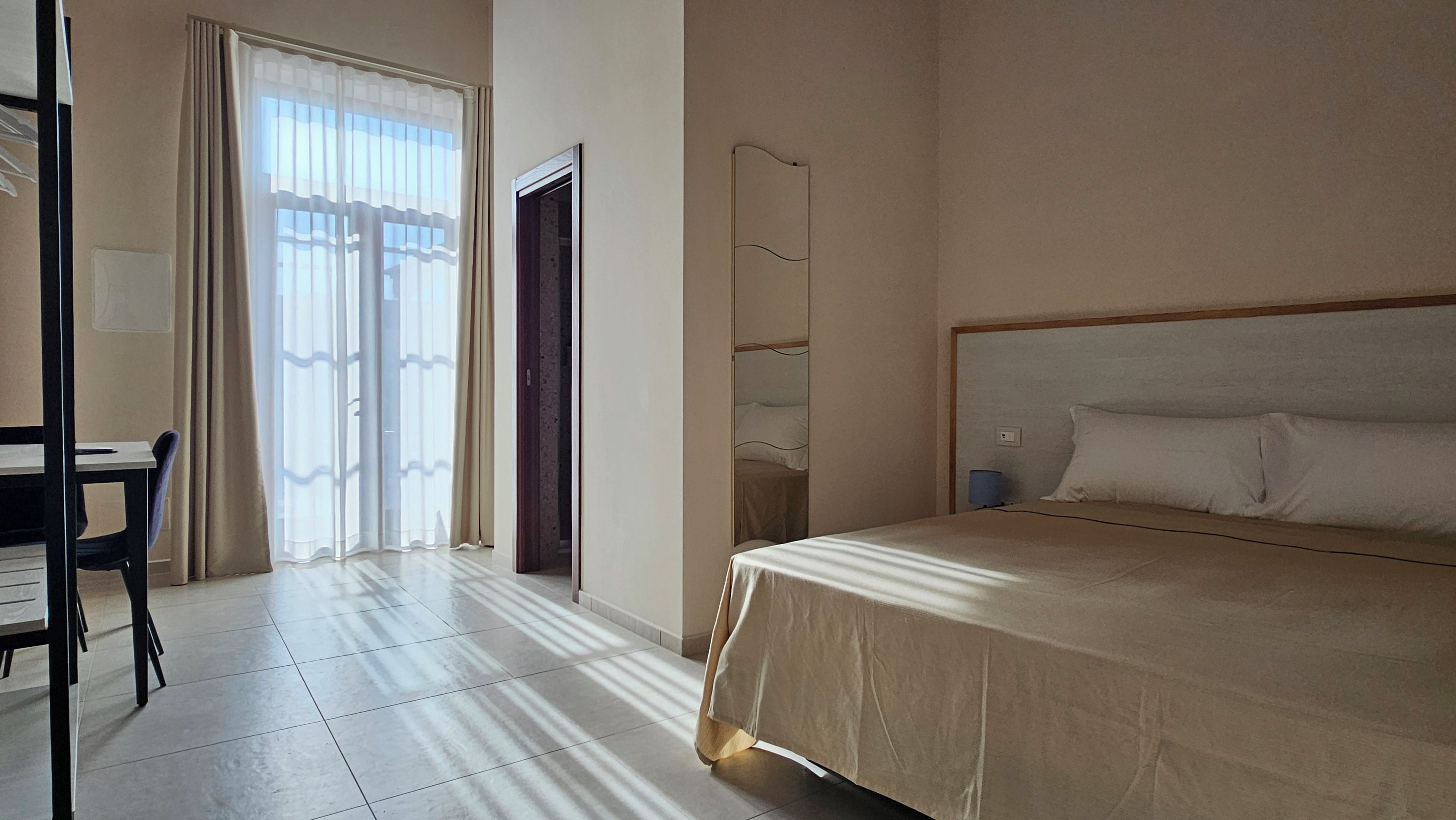 Ein Hotelzimmer mit Bett, Schreibtisch und Stuhl.