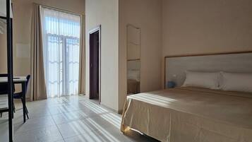 Ein Hotelzimmer mit Bett, Schreibtisch und Stuhl.