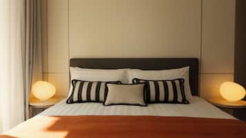 A neatly made bed with striped pillows and a brown blanket, flanked by two bedside lamps on matching nightstands.