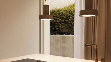 A modern kitchen with a large window, a built-in stove, and pendant lighting.