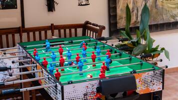 Una mesa de fútbol de mesa en una habitación con obras de arte enmarcadas en las paredes.