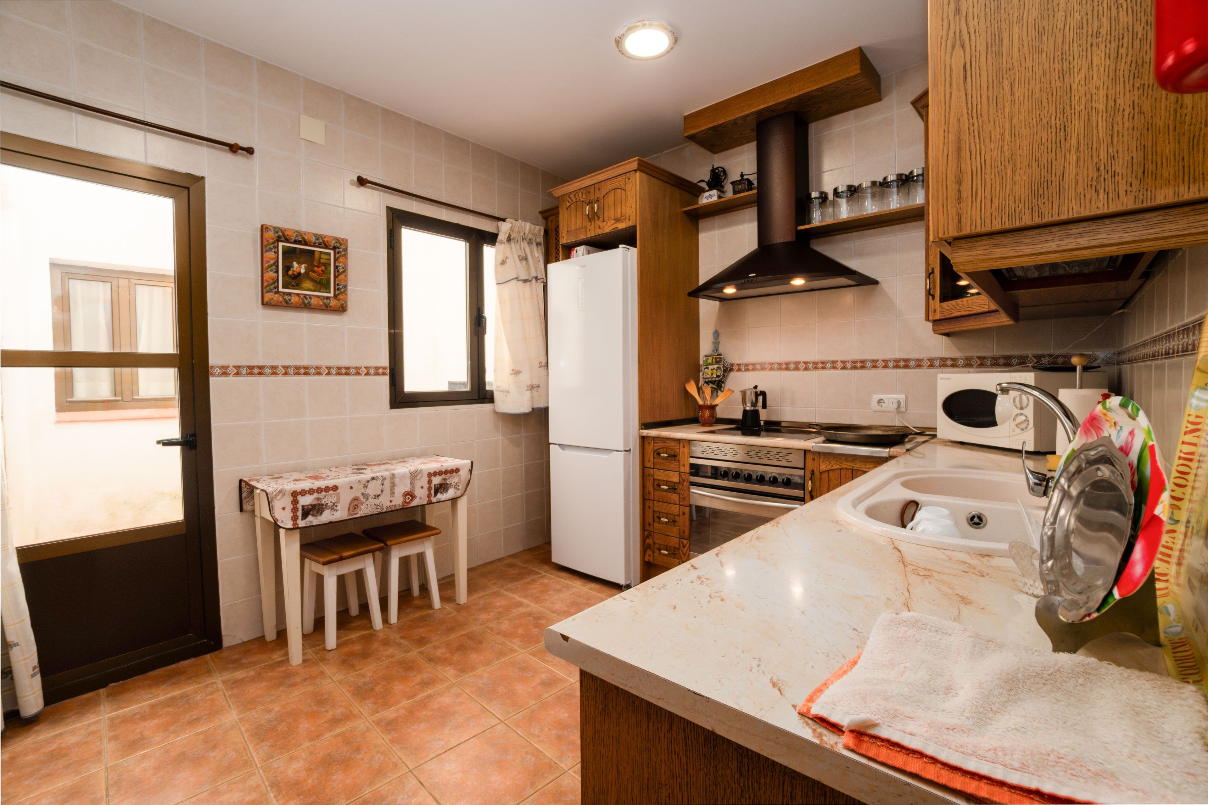 Una cocina equipada con refrigerador, estufa, microondas y gabinetes de madera.