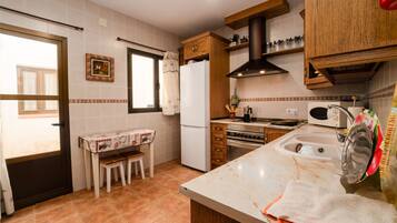 Una cocina equipada con refrigerador, estufa, microondas y gabinetes de madera.