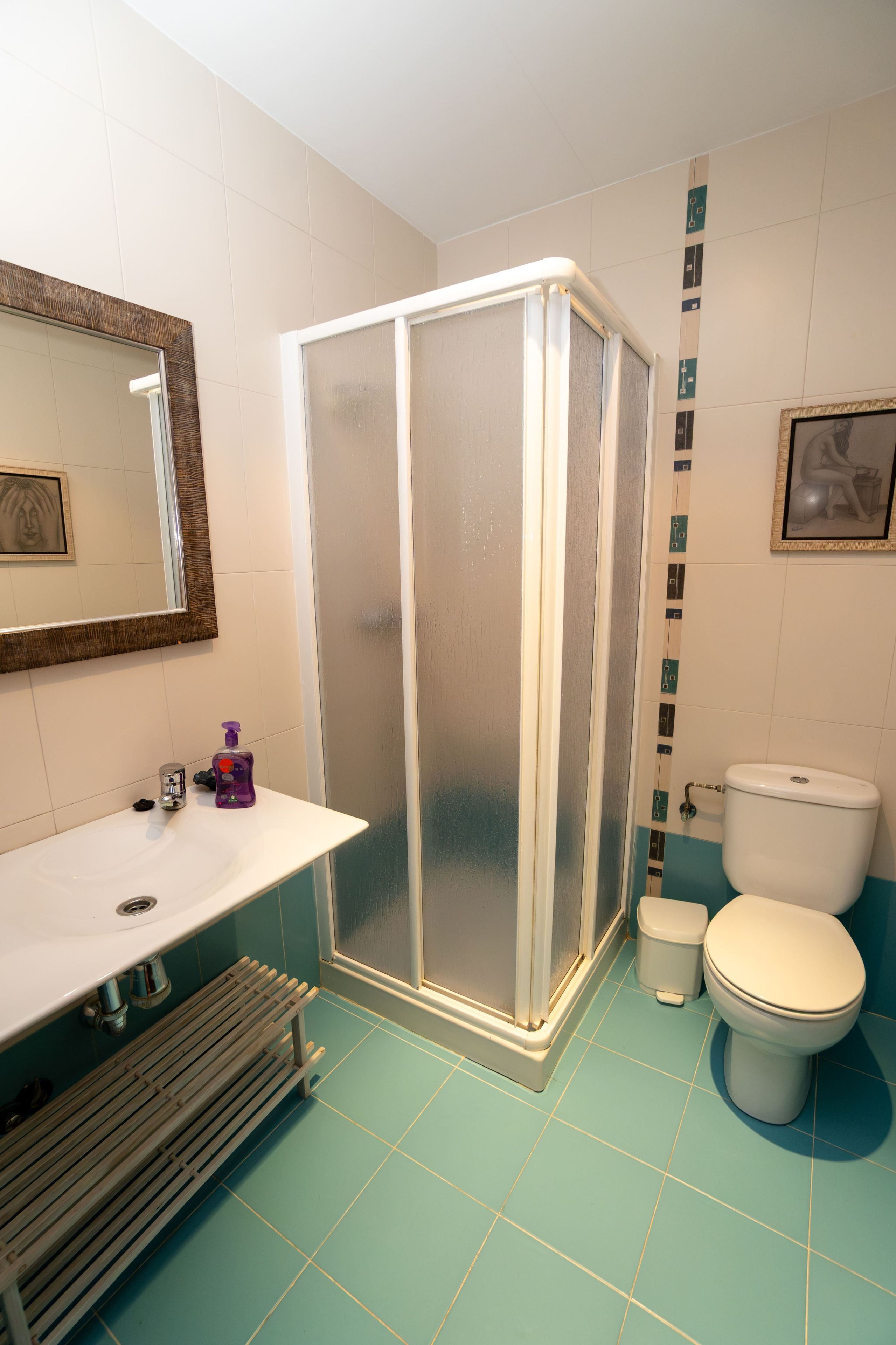 Un baño con cabina de ducha, inodoro, lavabo y espejo.
