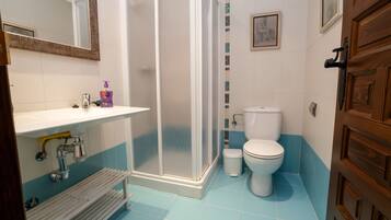 Un baño con ducha, inodoro y lavamanos.