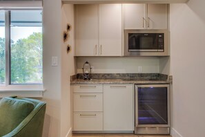 A compact kitchen with a built-in microwave, a wine glass on the counter, and a built-in oven. - Richardson Retreat - Pool, Hot Tub & Fire Pit (Richardson)