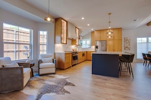 A spacious kitchen with wooden cabinets, a central island, and pendant lighting. - Richardson Retreat - Pool, Hot Tub & Fire Pit (Richardson)