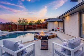 A backyard with a swimming pool, a fire pit, and outdoor seating. - Richardson Retreat - Pool, Hot Tub & Fire Pit (Richardson)