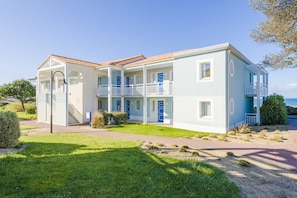 A two-story building with a balcony, a staircase, and a view of the sea. - Oceanfront Suite for Five (Les Sables-d'Olonne)