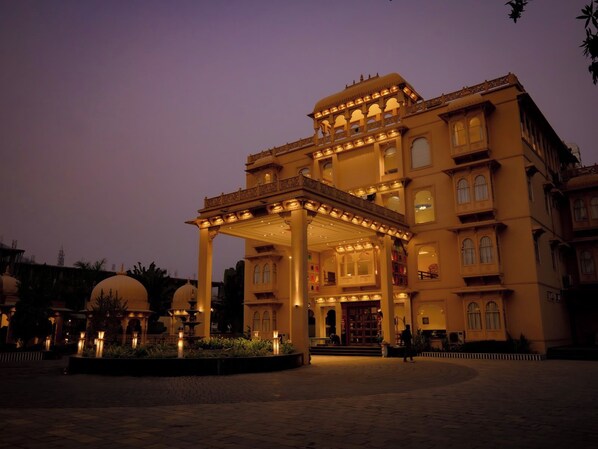A multi-story building with a covered entrance and a fountain in the foreground. - Tathastu Heritage Resort (Udaipur)