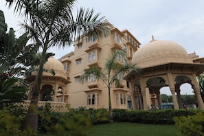 A traditional building with multiple domes and arches, surrounded by lush greenery. - Tathastu Heritage Resort (Udaipur)