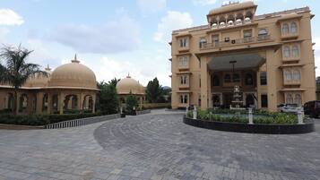 A large building with multiple domes and a fountain in the courtyard.
