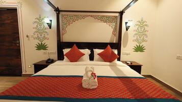 Ein Hotelzimmer mit Himmelbett, Bettwäsche in Rot und Weiß, einem Handtuch mit Blumenmuster und Wandbildern.