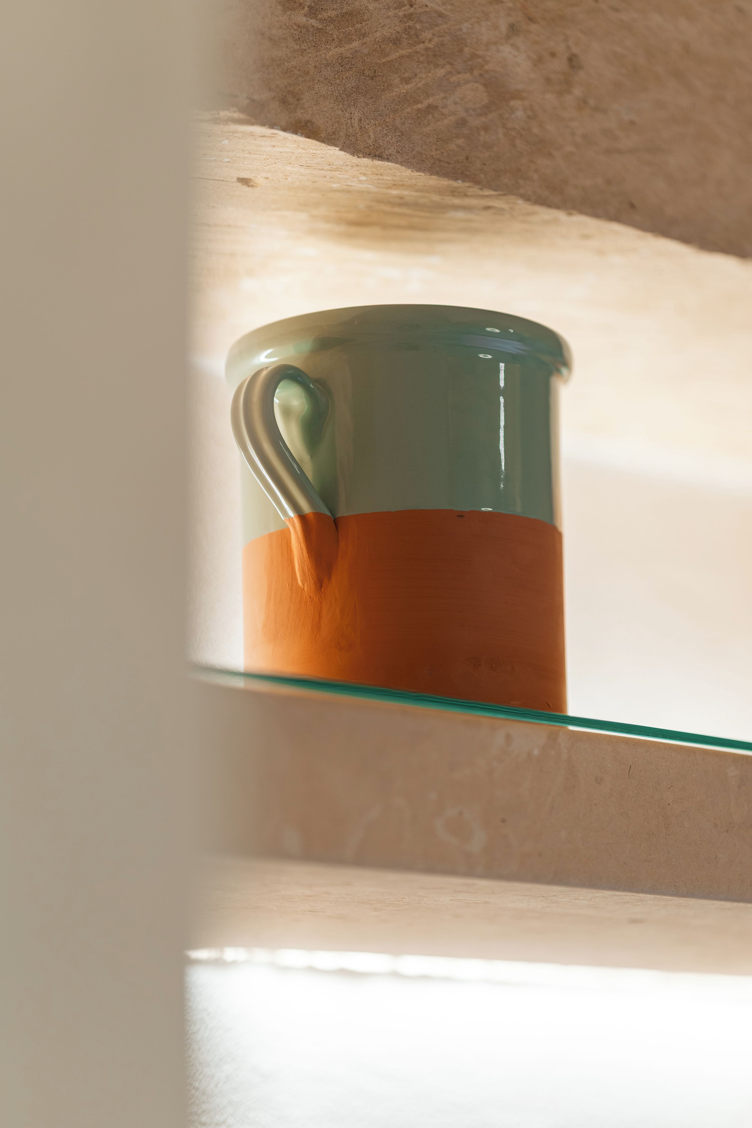 A glass mug on a shelf.