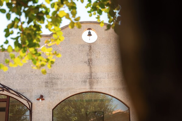 A building with a clock on the wall and a large arched window.
