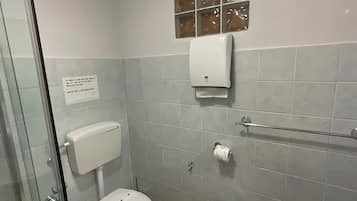Een badkamer met toilet, bidet en een douchecabine.