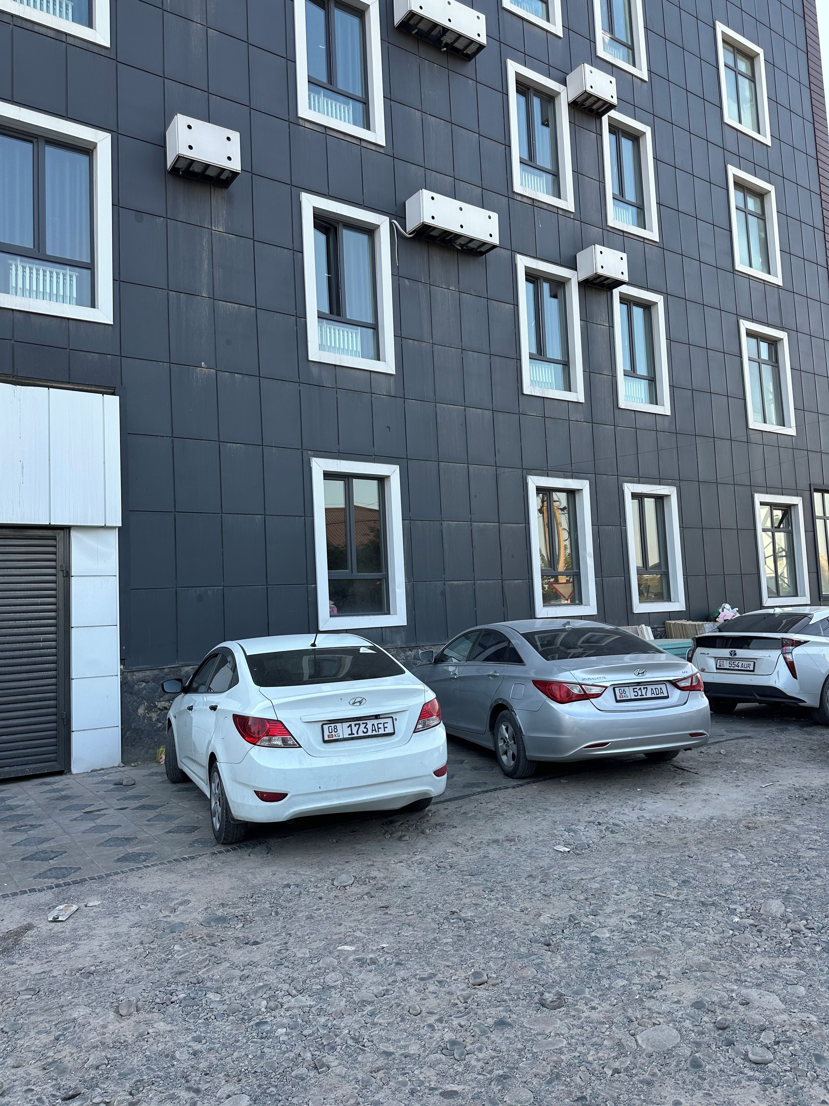 Un edificio con diverse finestre e un'area di parcheggio con auto.