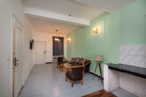Una sala de estar con sofá, sillas, una mesa de centro y una lámpara.