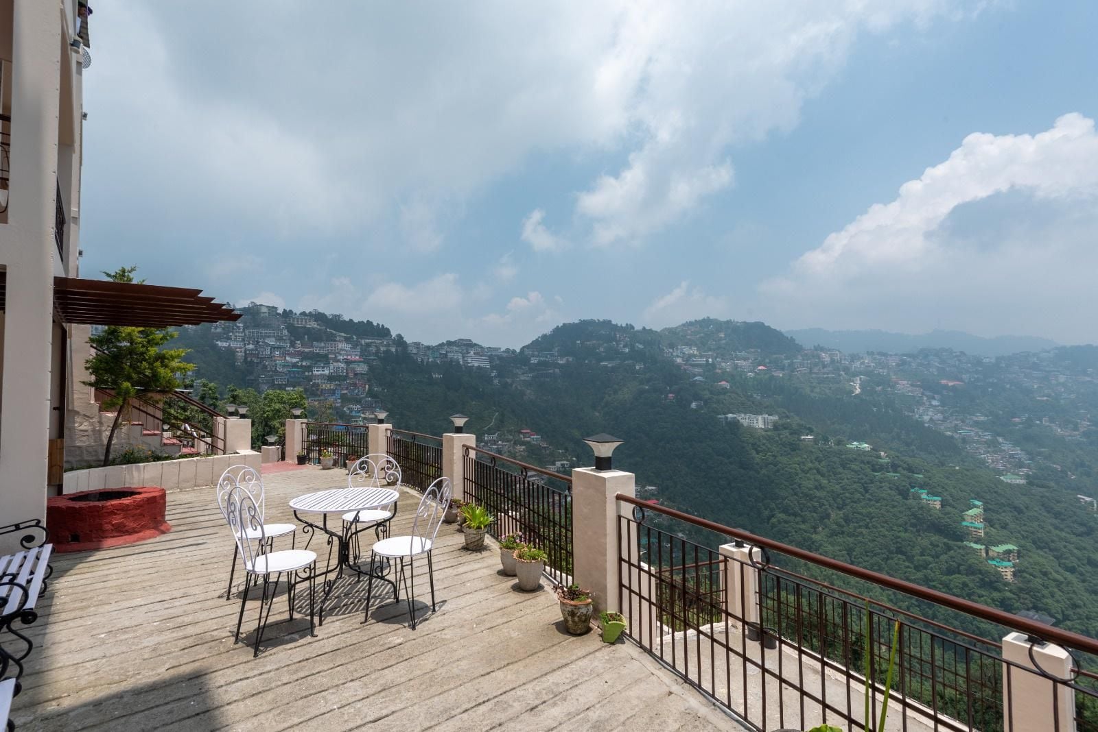 Una terraza con mobiliario exterior y vistas a un paisaje montañoso.