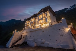 Un hotel de varios pisos con balcón, llamado 'The Ridge', ubicado en una ladera.