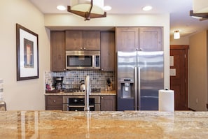 A kitchen with a stainless steel refrigerator, a microwave, and a coffee maker. - Peakside at One Ski Hill: Peak 8 Ski-In/Out, 2 Baths, A/C, Pools, Shuttle (Breckenridge)