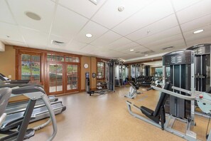 Ein Fitnessstudio mit Laufbändern, Krafttrainingsgeräten und einem Wasserspender.
