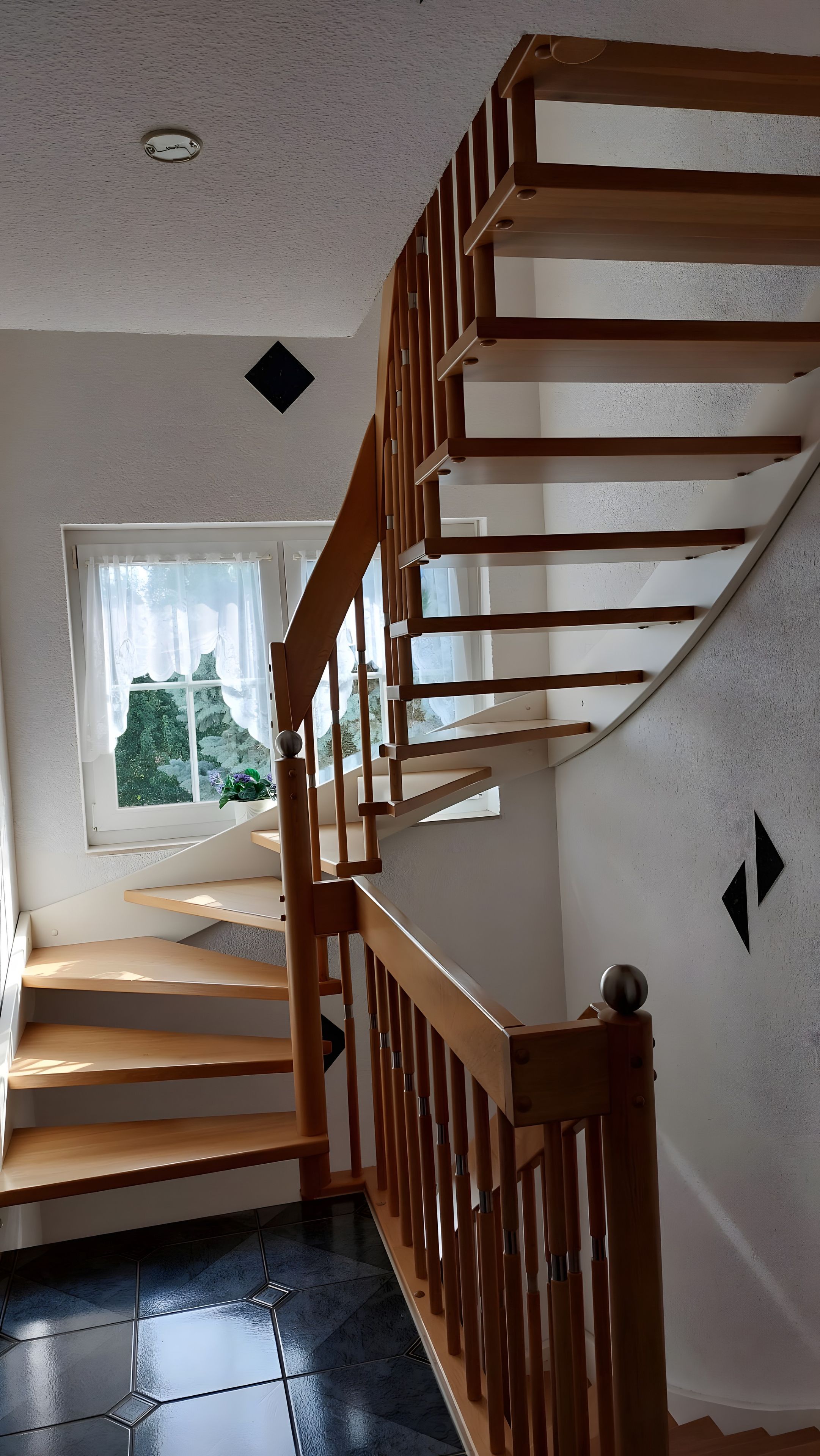 A wooden staircase with a handrail leading to a landing.