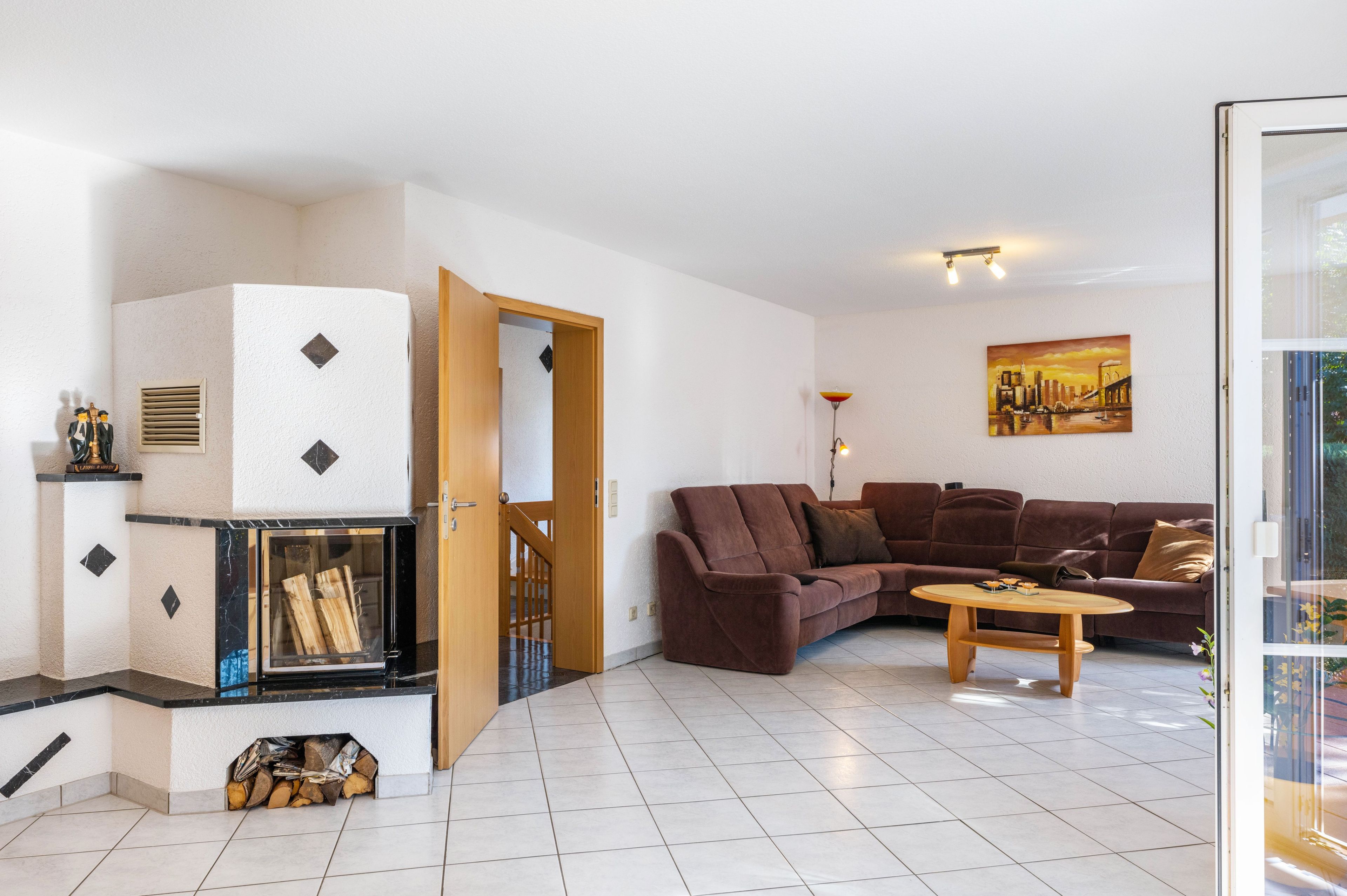A living room with a fireplace, a sofa, a coffee table, and a painting on the wall.