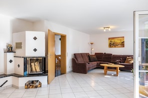 A living room with a fireplace, a sofa, a coffee table, and a painting on the wall.