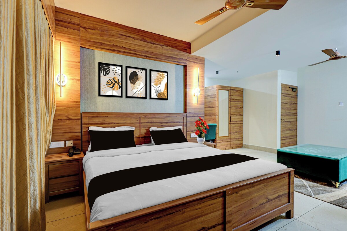 Un dormitorio moderno con estructura de cama de madera, una mesita de noche y una lámpara, además de una obra de arte en la pared.