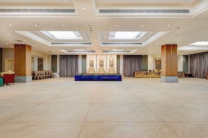 A spacious hall with a stage, seating, and a high ceiling with skylights.