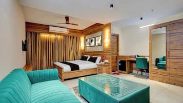 Un dormitorio moderno con cama, sofá verde, escritorio y espejo.