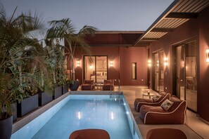 A modern outdoor pool area with lounge seating and a view of the interior. - Moncasa Segreta Collection (Agios Nikolaos)