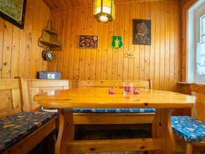 Ein Holzkamin mit Tisch und Bänken, einer Uhr und Wanddekorationen.