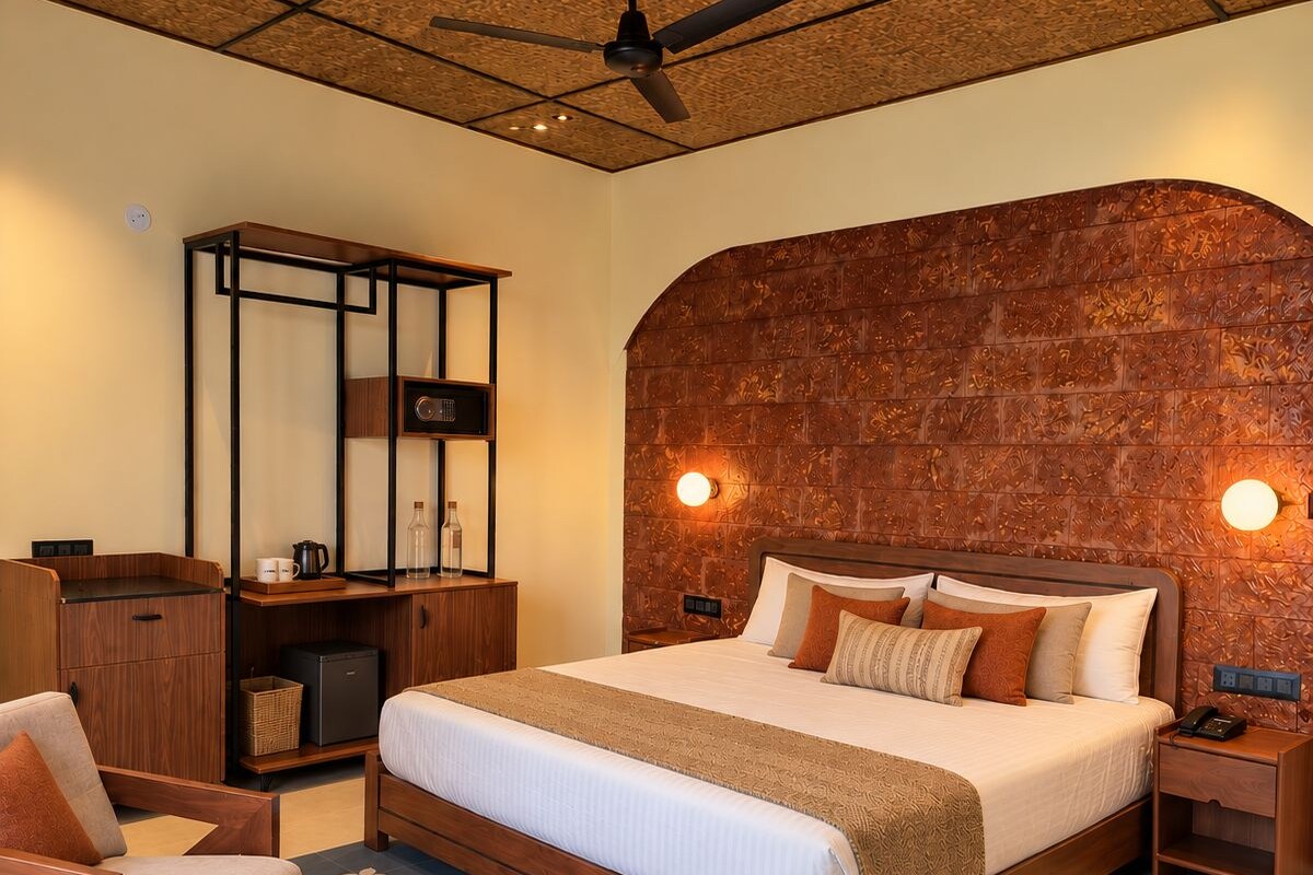 Habitación de hotel con una cama grande, un escritorio, una silla, una mesa redonda y un ventilador de techo.