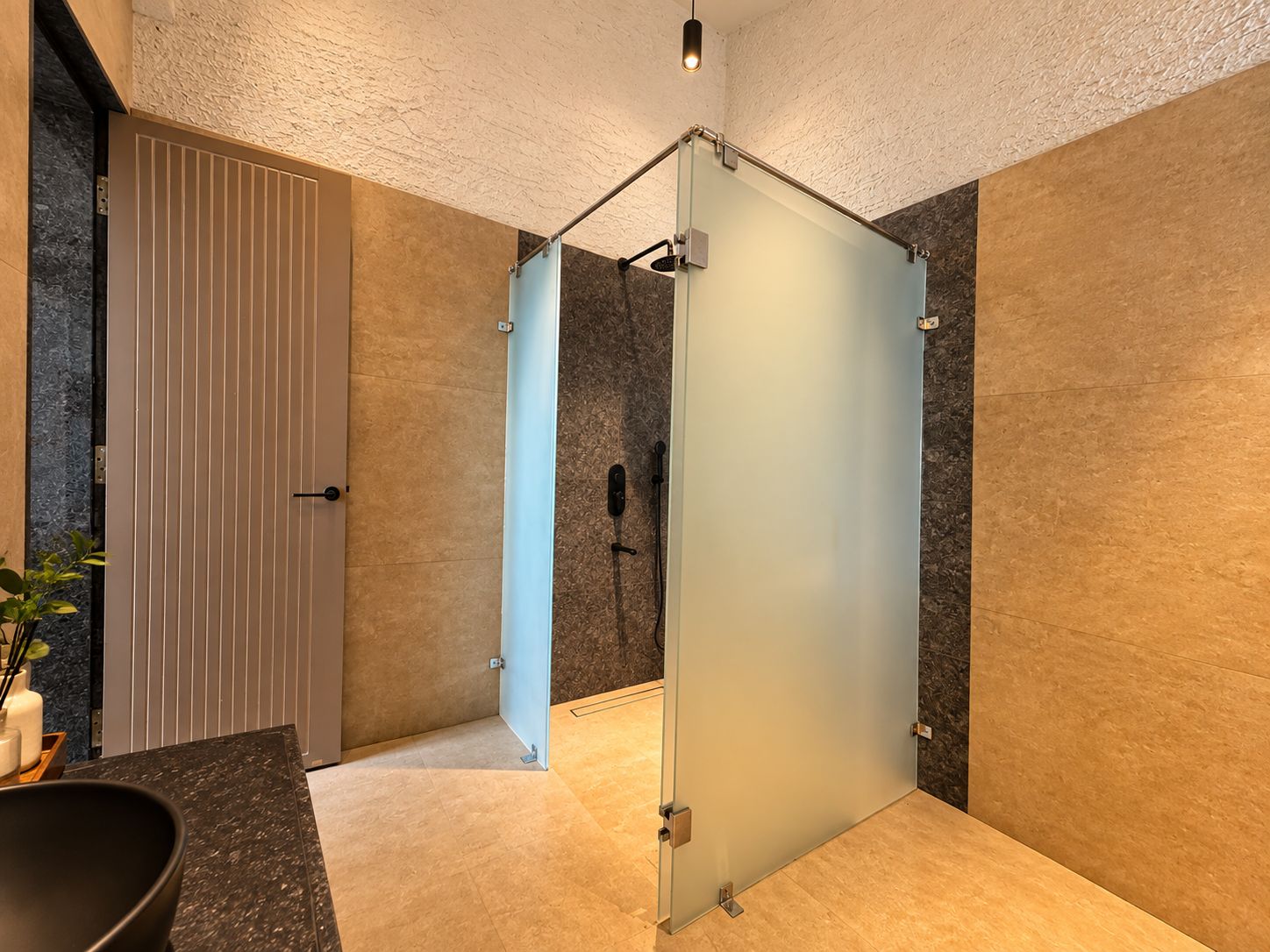 A modern bathroom with a glass partition, a shower area, and a marble countertop.
