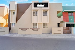 A modern townhouse with a sign indicating it is serviced by OYO.