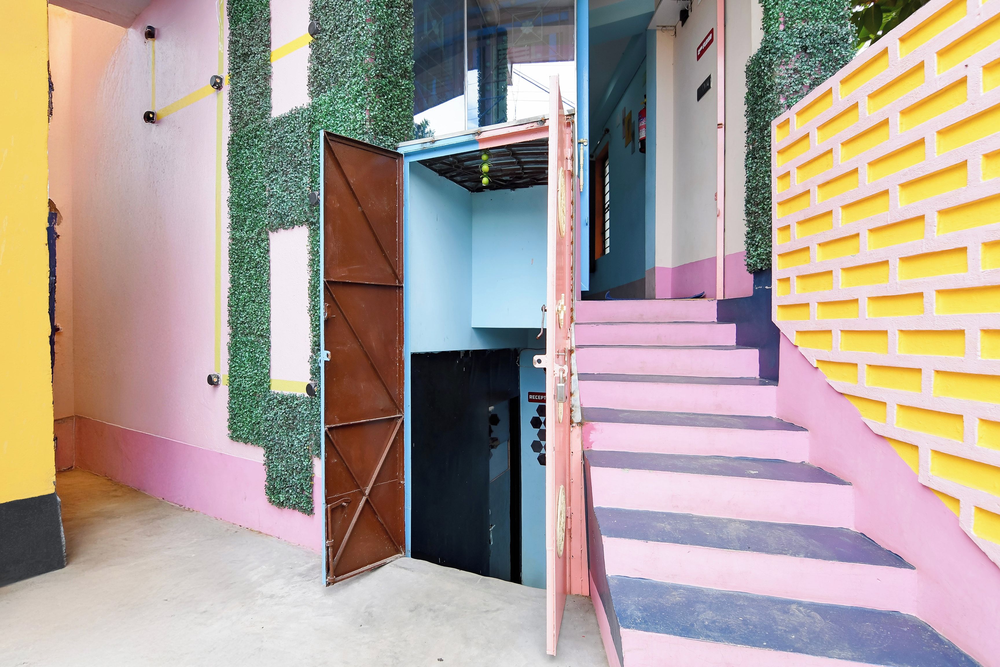 A multi-level building with a staircase, a reception area, and a door leading to an interior space.