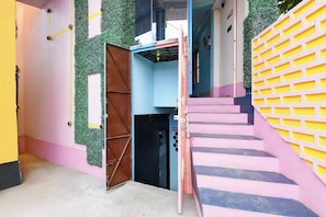 Un edificio de varios niveles con una escalera, una zona de recepción y una puerta que da a un espacio interior.