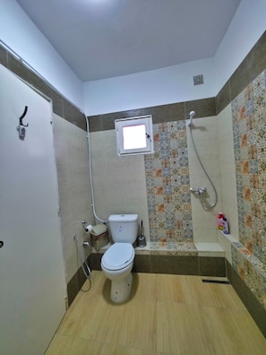A small bathroom with a toilet, a shower, and a wall-mounted window. - Apartment marina kantaoui sousse (Hammam Sousse)