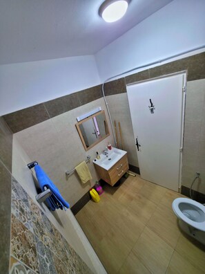 Ein Badezimmer mit Toilette, Waschbecken, Spiegel und Handtuchhalter.