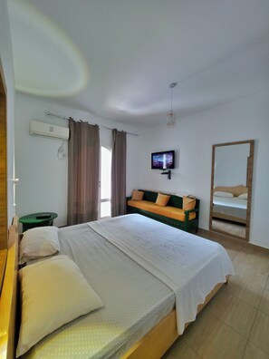 A hotel room with a bed, a television, a mirror, and a green table. - Apartment marina kantaoui sousse (Hammam Sousse)
