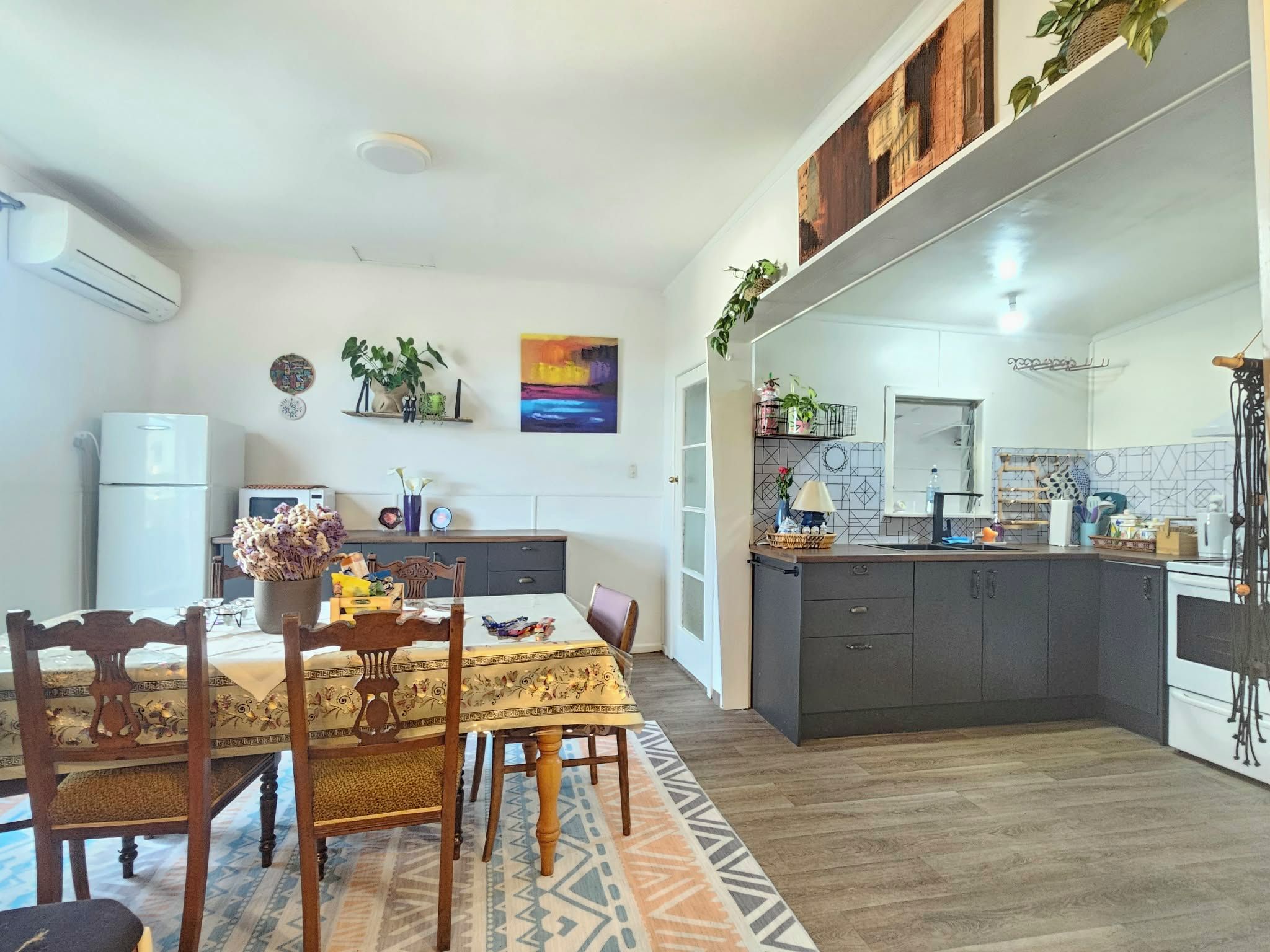 A modern kitchen with a central island, built-in appliances, and a dining area with a table and chairs.