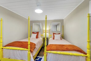 A room with two single beds, each with a headboard and footboard, a ceiling light, and a mirror on the wall. - Lake Winnipesaukee Waterfront Sandy Beach 40 Ft Dock Sleeps 10 (Moultonborough)