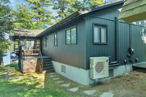 A cabin with a deck, a stairway, and an air conditioning unit. - Lake Winnipesaukee Waterfront Sandy Beach 40 Ft Dock Sleeps 10 (Moultonborough)