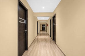 A hotel corridor with doors numbered 201, 202, and 203, leading to rooms. - Collection O Dahisar Mori Kalyan Phata (Thane)