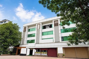 A modern building with a sign that reads 'Collection' and a large tree in front. - Collection O Dahisar Mori Kalyan Phata (Thane)