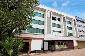 A modern building with multiple floors, large windows, and a sign indicating a collection or service. - Collection O Dahisar Mori Kalyan Phata (Thane)